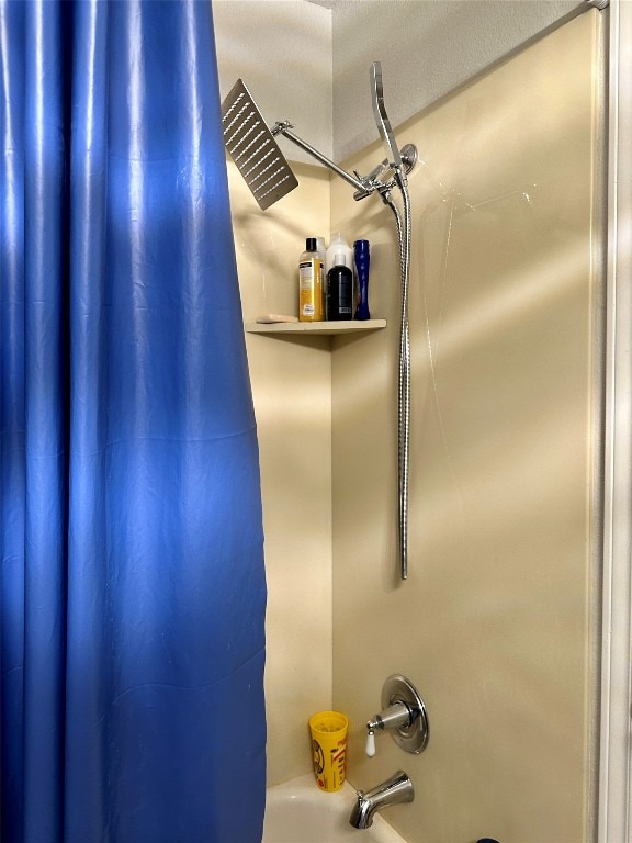 details featuring shower / bathtub combination with curtain and a textured ceiling