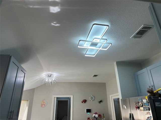 details featuring stainless steel refrigerator and a textured ceiling