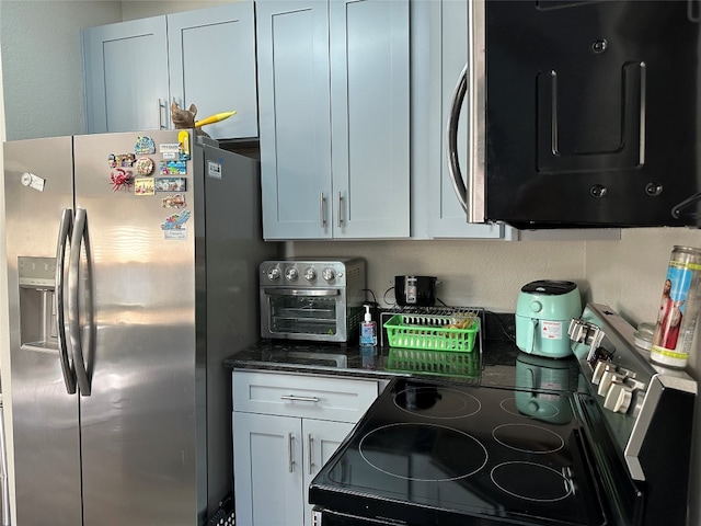 kitchen featuring white cabinets, dark stone counters, and appliances with stainless steel finishes