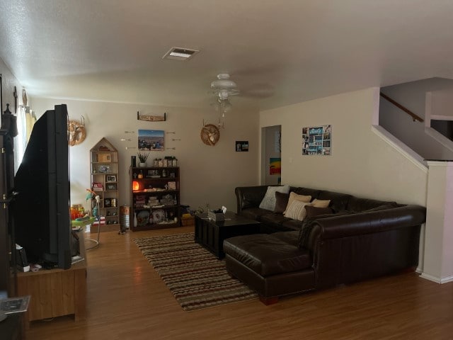 living room with dark hardwood / wood-style flooring and ceiling fan