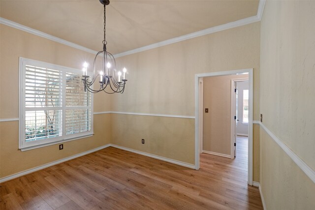 unfurnished room with wood-type flooring, plenty of natural light, and an inviting chandelier