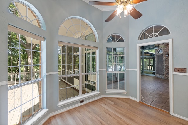 unfurnished sunroom featuring ceiling fan