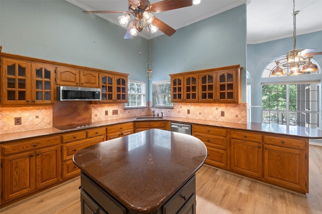 kitchen featuring a kitchen island, appliances with stainless steel finishes, light hardwood / wood-style floors, and backsplash