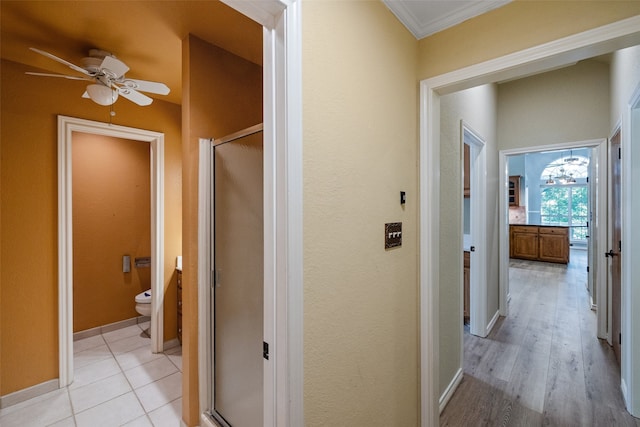 hall with light tile floors and ornamental molding