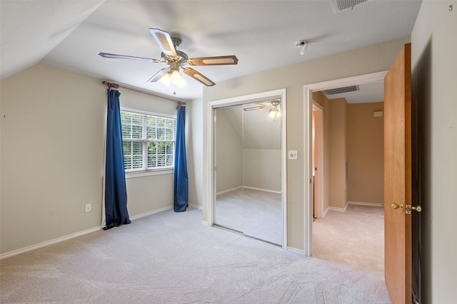 unfurnished bedroom with light colored carpet, ceiling fan, a closet, and lofted ceiling