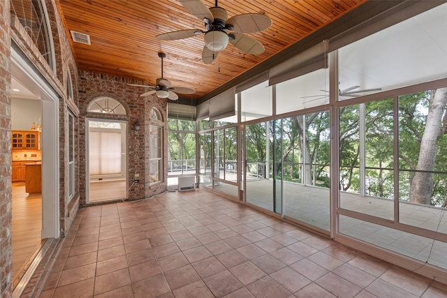 unfurnished sunroom with wood ceiling and ceiling fan