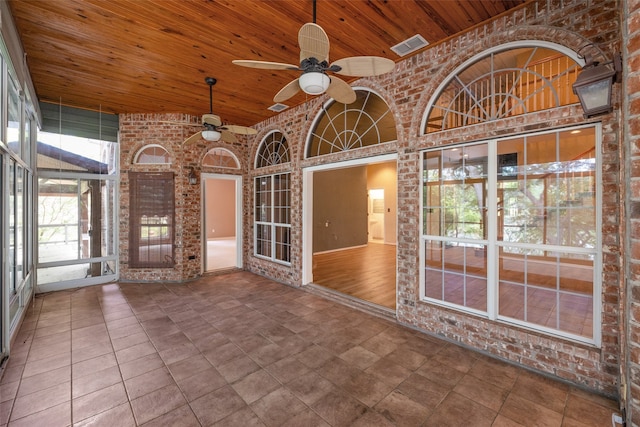 unfurnished sunroom with wood ceiling, plenty of natural light, and ceiling fan