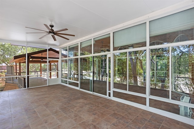 unfurnished sunroom with ceiling fan