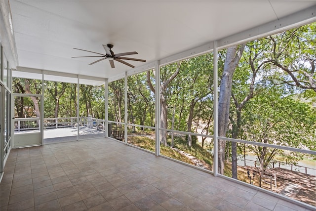 unfurnished sunroom featuring ceiling fan