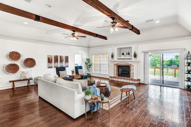 living room with a brick fireplace, a wealth of natural light, dark hardwood / wood-style floors, and beamed ceiling