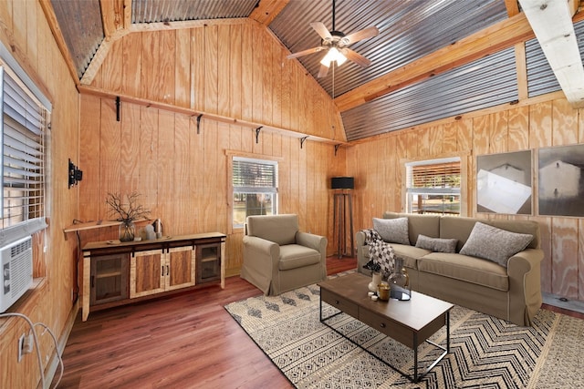 living room with ceiling fan, wooden walls, and a healthy amount of sunlight