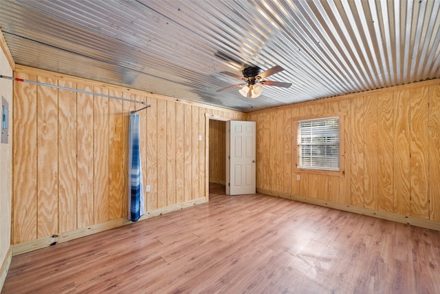 spare room featuring wooden ceiling, ceiling fan, light hardwood / wood-style flooring, and wooden walls