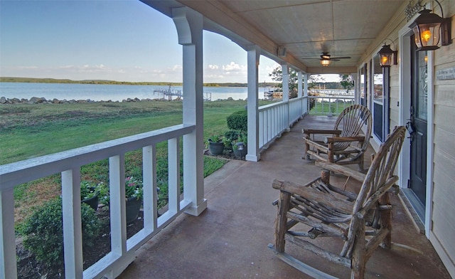 view of patio / terrace featuring ceiling fan, a porch, and a water view