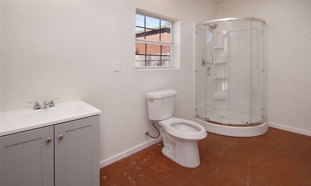 bathroom with vanity, a shower with door, and toilet