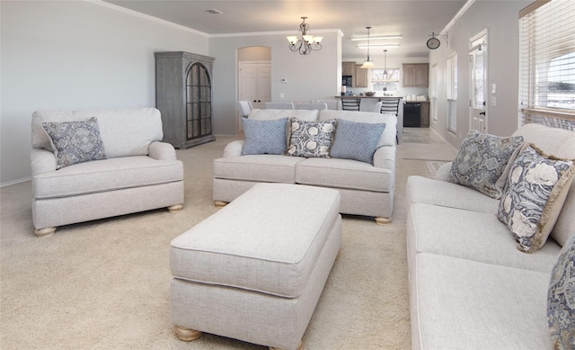 carpeted living room with ornamental molding and a chandelier