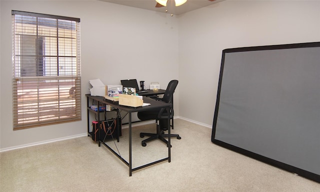 carpeted office space featuring ceiling fan