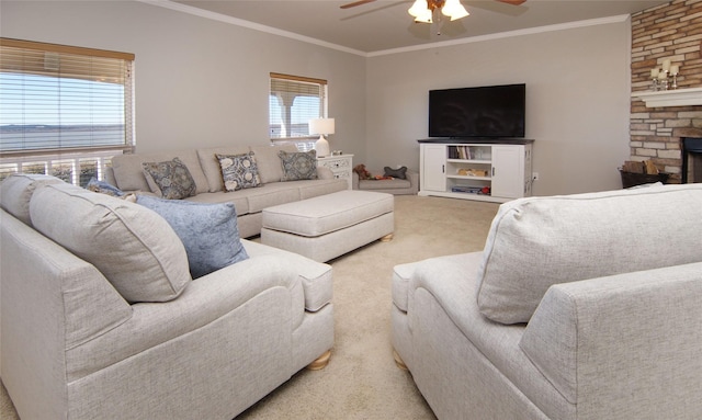 living room with ceiling fan, light colored carpet, ornamental molding, and a stone fireplace