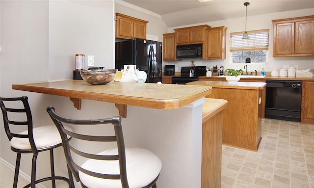 kitchen with hanging light fixtures, crown molding, a kitchen bar, and black appliances