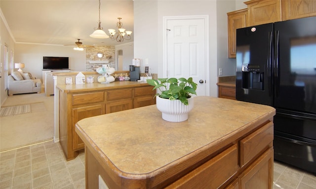 kitchen with pendant lighting, ceiling fan, a center island, black fridge with ice dispenser, and light colored carpet