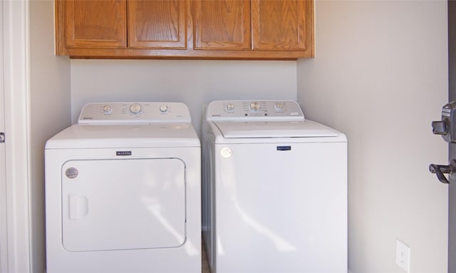 washroom with cabinets and washer and dryer