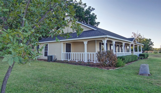 view of side of property featuring cooling unit, a porch, and a yard