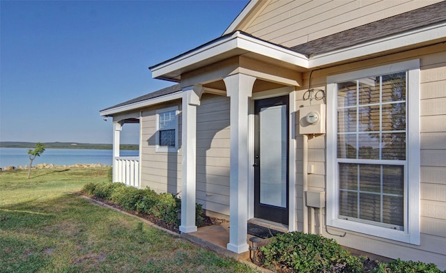 entrance to property with a lawn and a water view