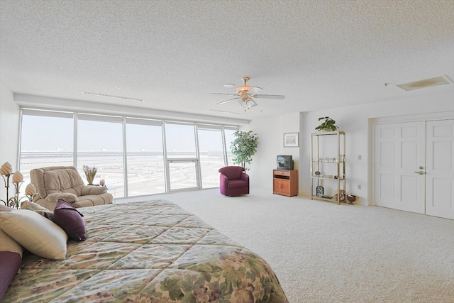 bedroom with carpet floors, access to exterior, ceiling fan, and a textured ceiling