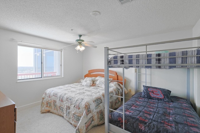 bedroom with carpet floors, ceiling fan, and a textured ceiling