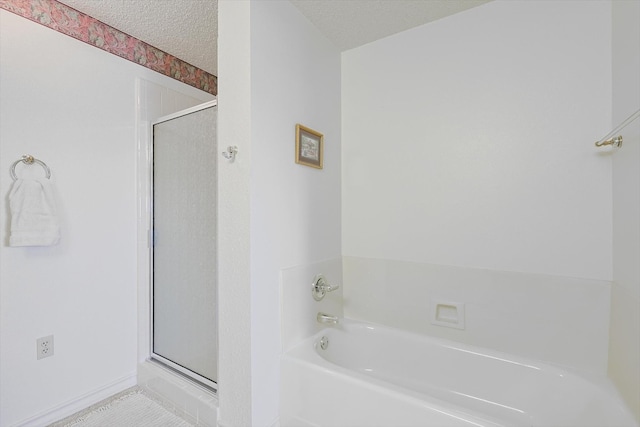 bathroom featuring shower with separate bathtub and a textured ceiling