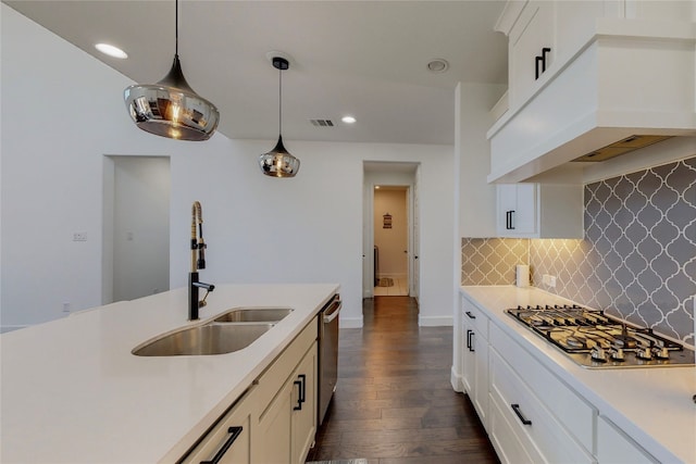 kitchen featuring appliances with stainless steel finishes, hanging light fixtures, backsplash, premium range hood, and dark hardwood / wood-style flooring