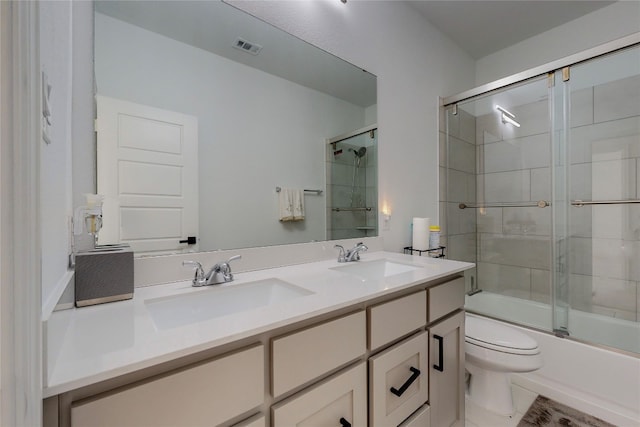 full bathroom with tile floors, toilet, enclosed tub / shower combo, and double vanity