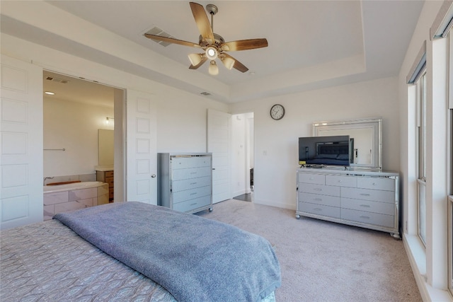 carpeted bedroom with ceiling fan and a tray ceiling