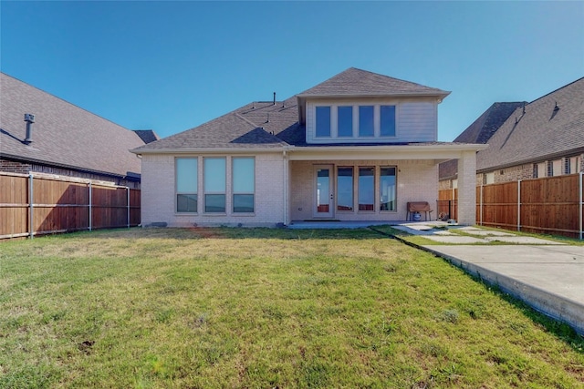 back of property with a yard and a patio area