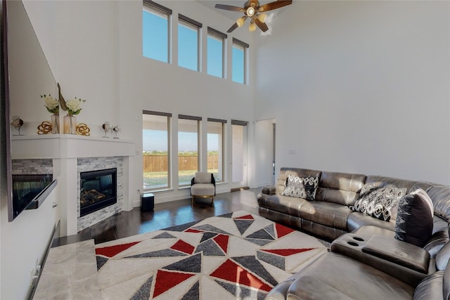 living room with a high ceiling, dark hardwood / wood-style floors, and ceiling fan