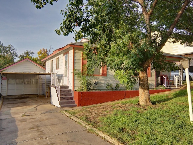 view of front of house featuring an outbuilding, a front yard, and a garage