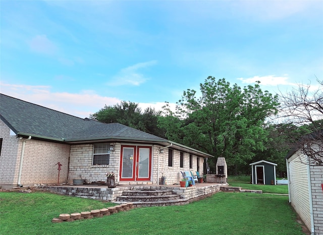 back of property with a yard and a shed