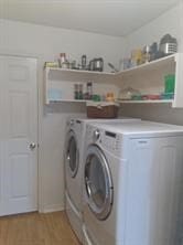 laundry room featuring light wood-type flooring and washer and clothes dryer