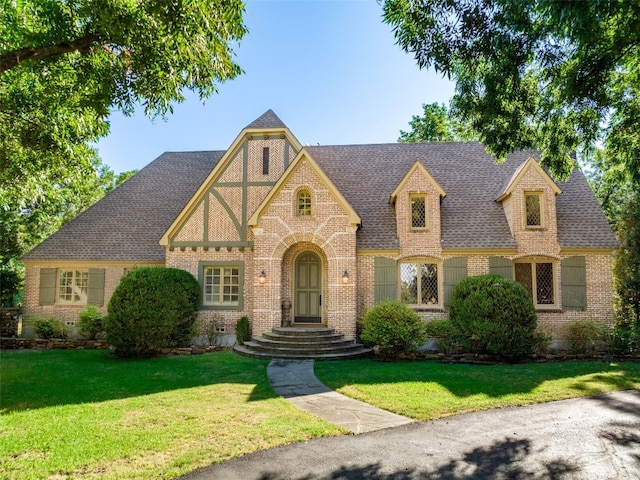 tudor-style house with a front lawn