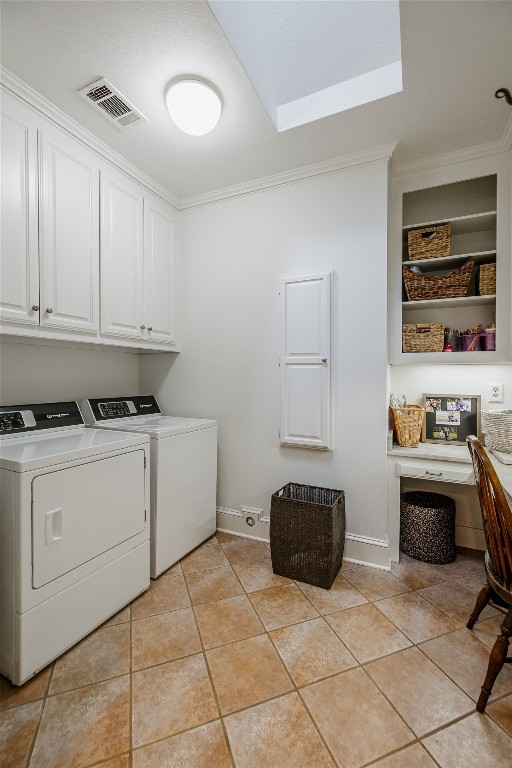 laundry room featuring ornamental molding, cabinets, light tile floors, and washer and dryer