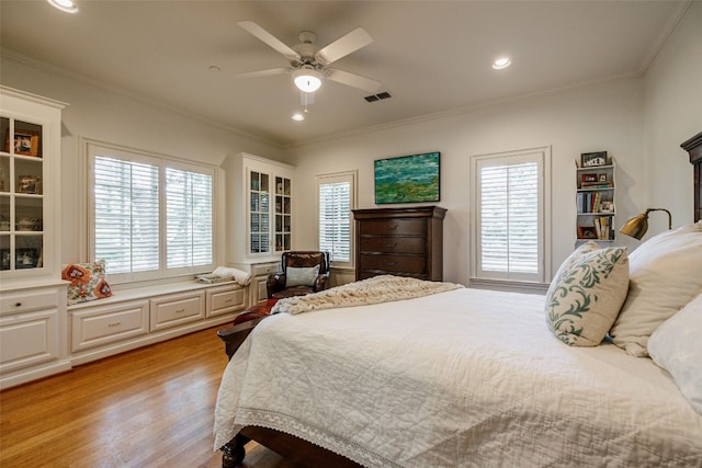 bedroom featuring crown molding, light hardwood / wood-style floors, and ceiling fan