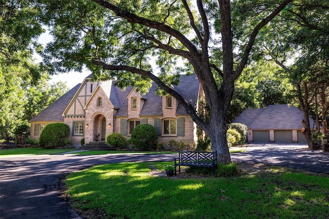 english style home with a front lawn and a garage