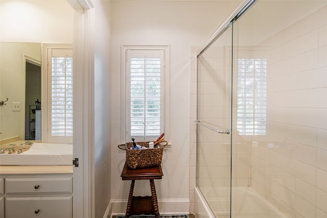 bathroom with shower / bath combination with glass door and vanity