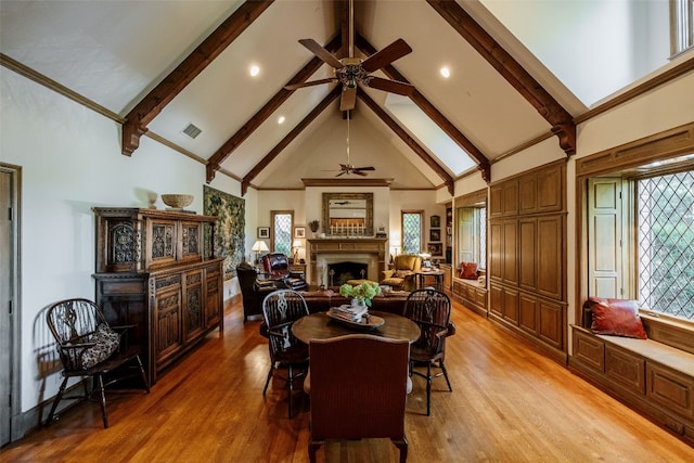 dining room with beam ceiling, high vaulted ceiling, light hardwood / wood-style floors, and ceiling fan