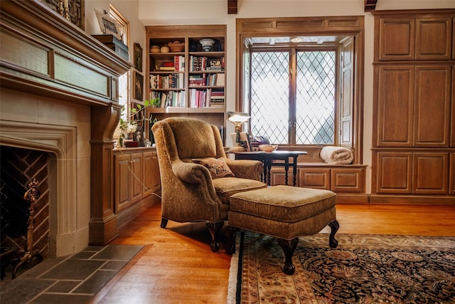 sitting room with built in features and light hardwood / wood-style floors