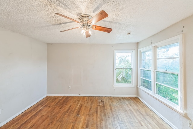 spare room featuring light wood-type flooring, a textured ceiling, and ceiling fan