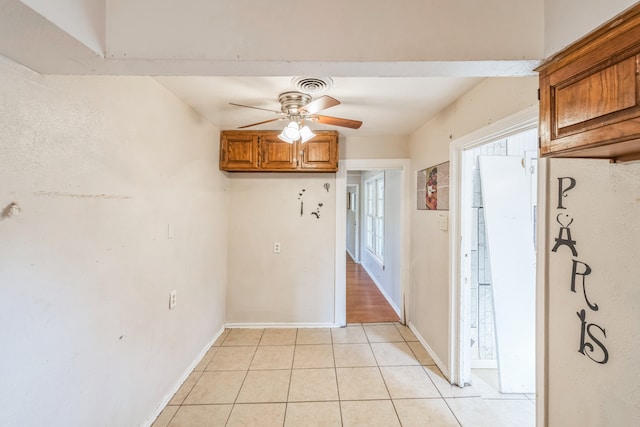 unfurnished dining area featuring light tile patterned floors and ceiling fan