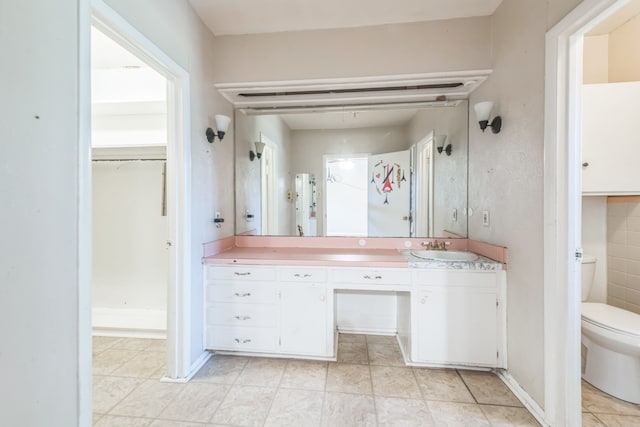 bathroom with tile patterned flooring, vanity, and toilet