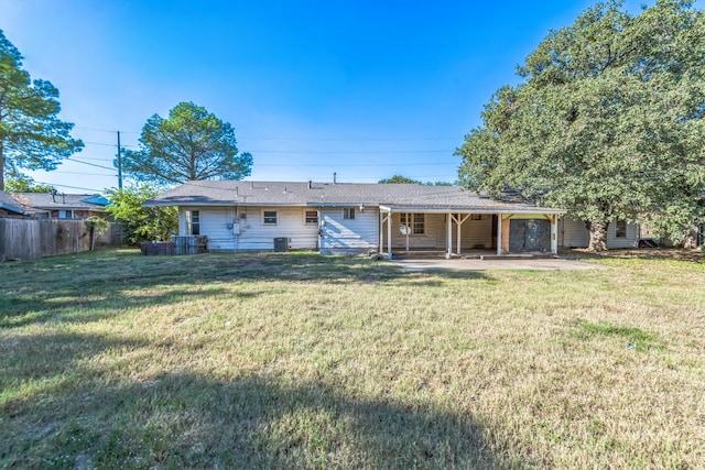 rear view of property featuring a patio and a yard