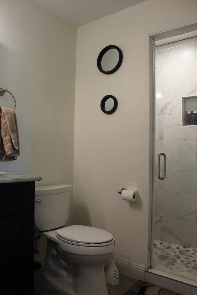 bathroom featuring vanity, toilet, and an enclosed shower