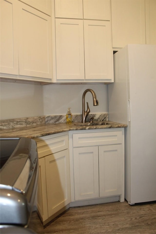 kitchen featuring white cabinetry, sink, dark hardwood / wood-style floors, and white refrigerator